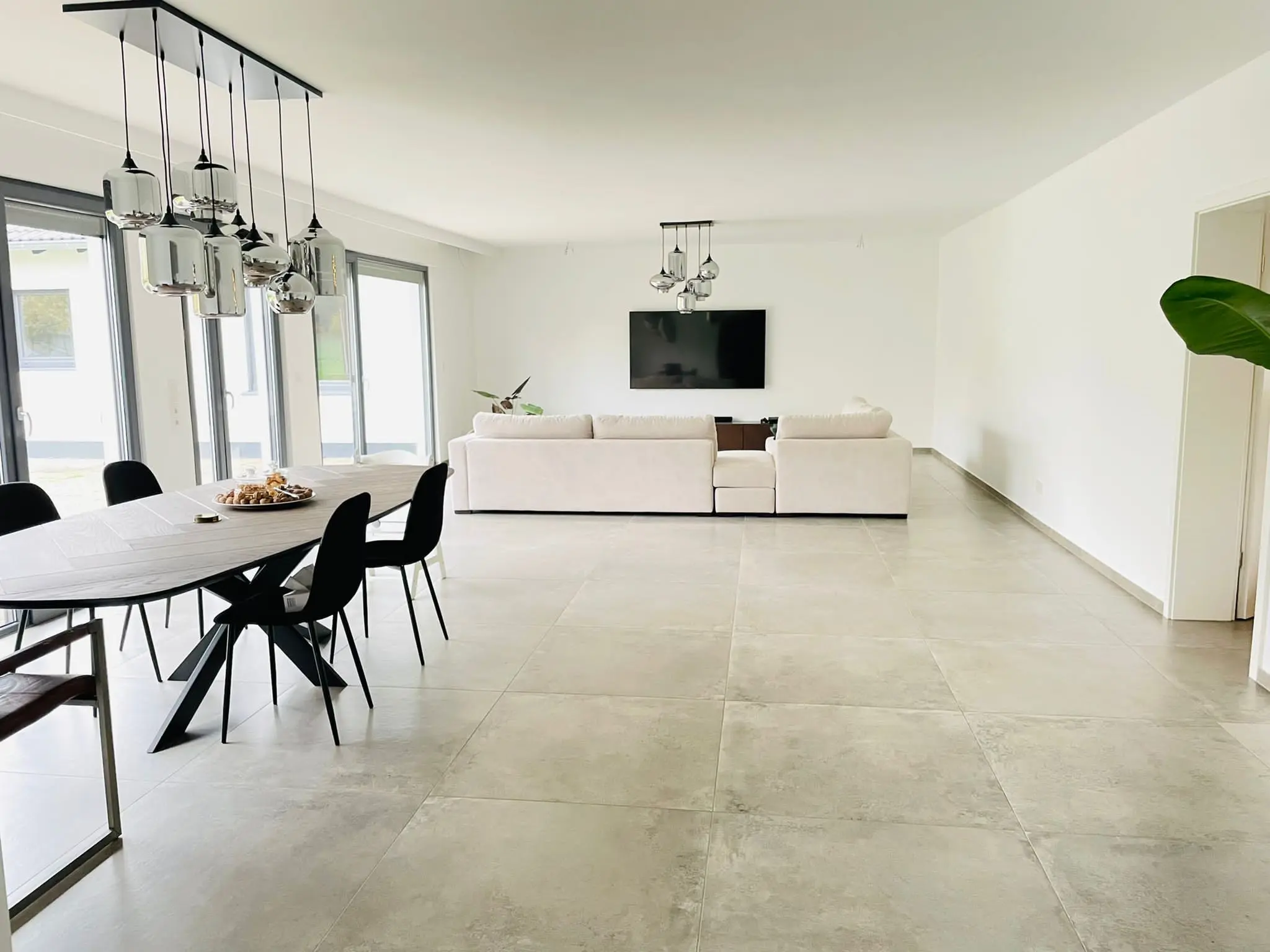 Ausgeführter Wohn- und Essbereich der Untergeschosswohnung mit großformatigem Boden